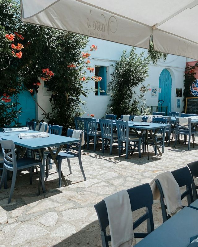 Σκιερή αυλή με τραπέζια, τέντα και βουκαμβίλιες